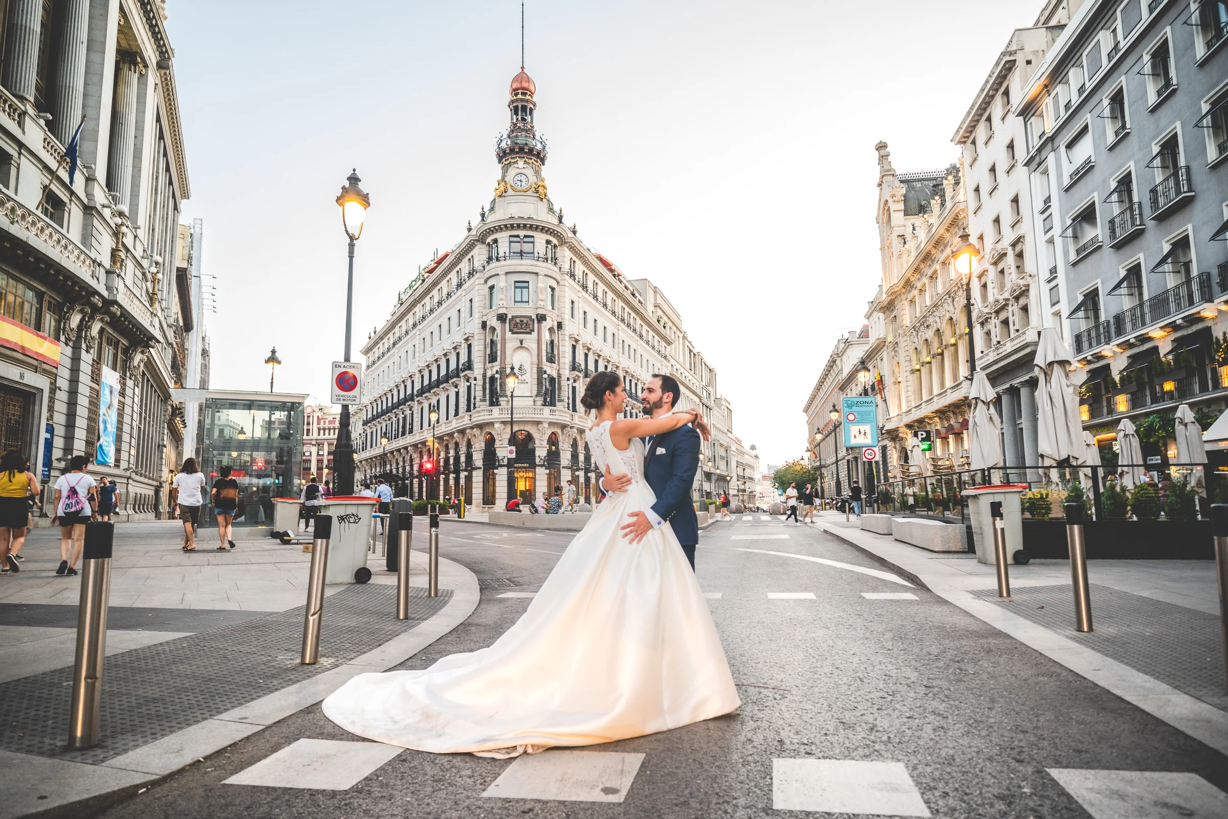Sara y Edu bailan en la calle con el Edificio Metrópolis al fondo durante su postboda por Gran Vía y la calle de Alcalá.