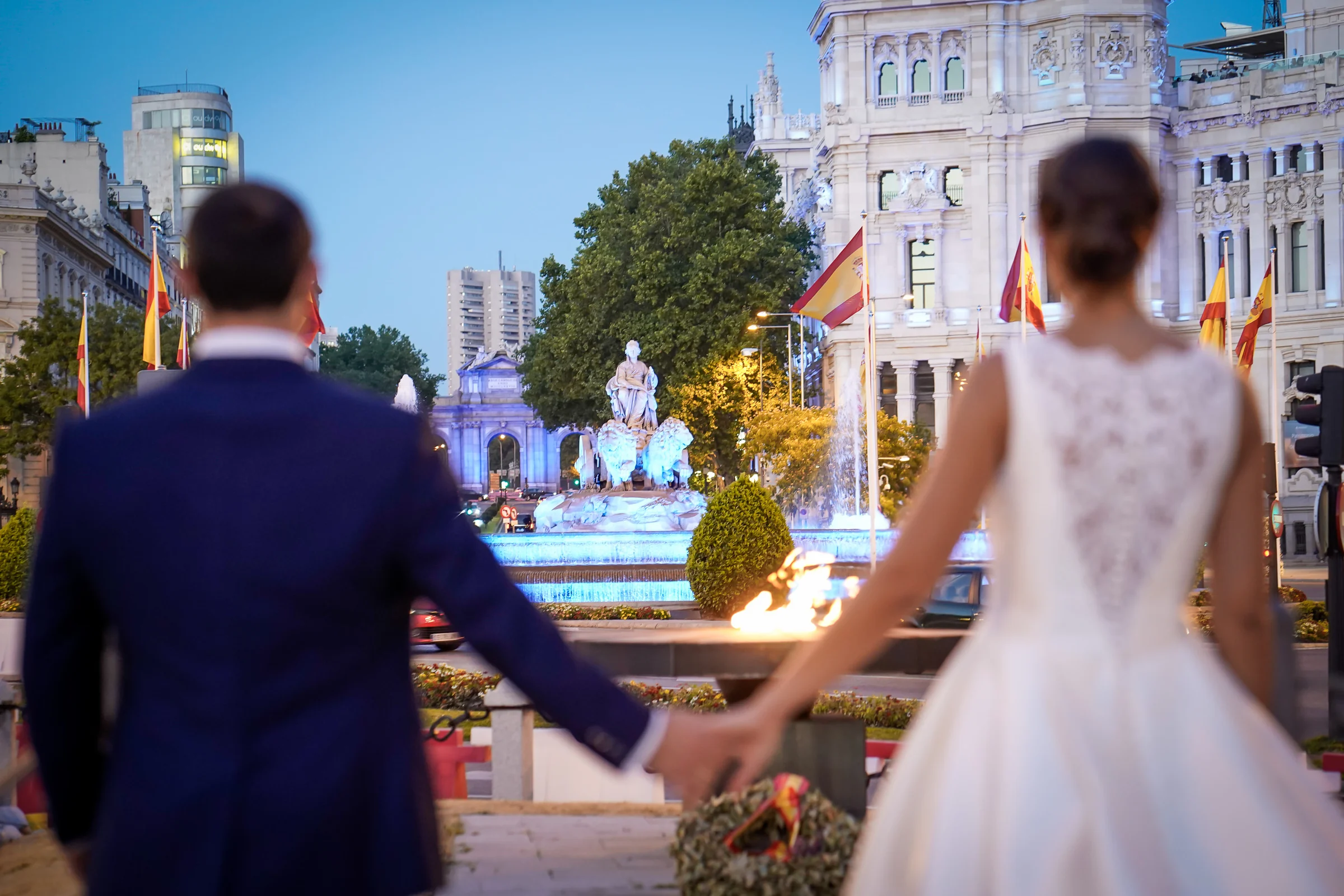 Sara y Edu contemplan la fuente de Cibeles y el Palacio de Cibeles durante el atardecer de su postboda en Madrid.