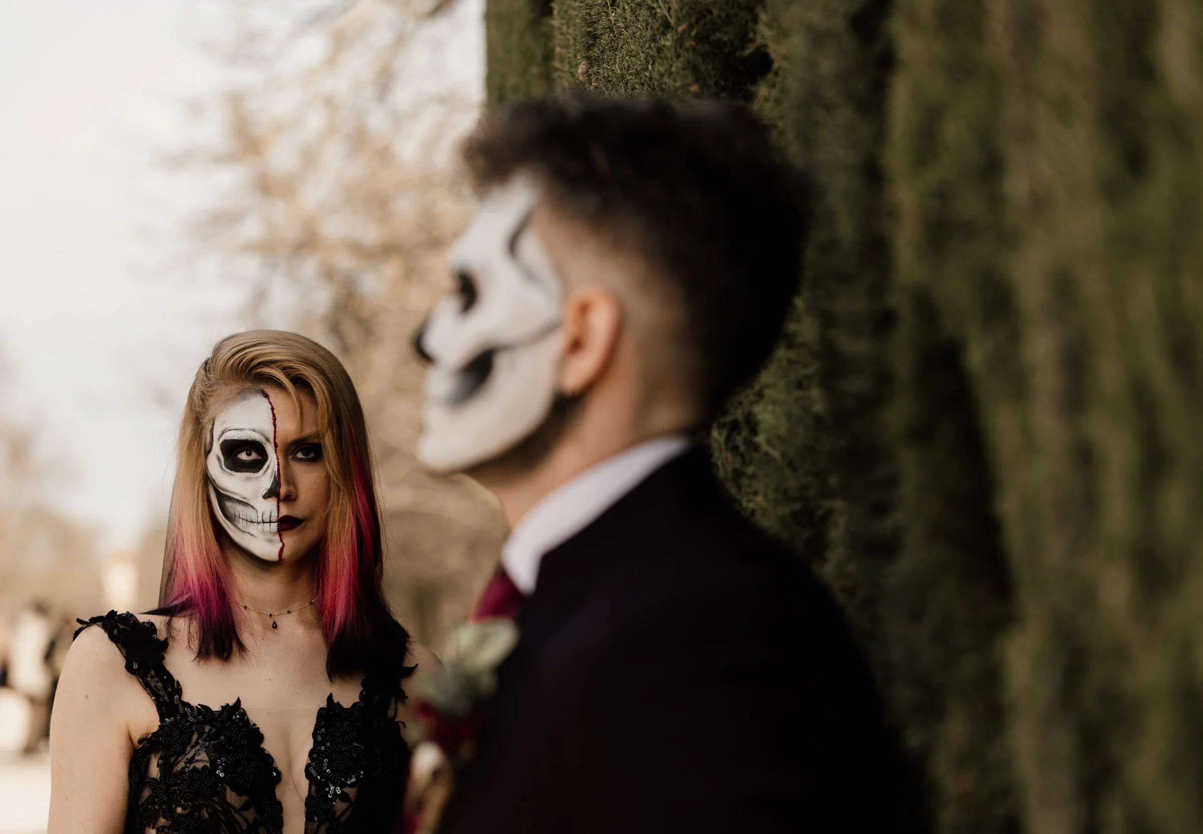 Silvia mira a Rubén en un retrato cercano que destaca su maquillaje de calavera durante la postboda en El Retiro.