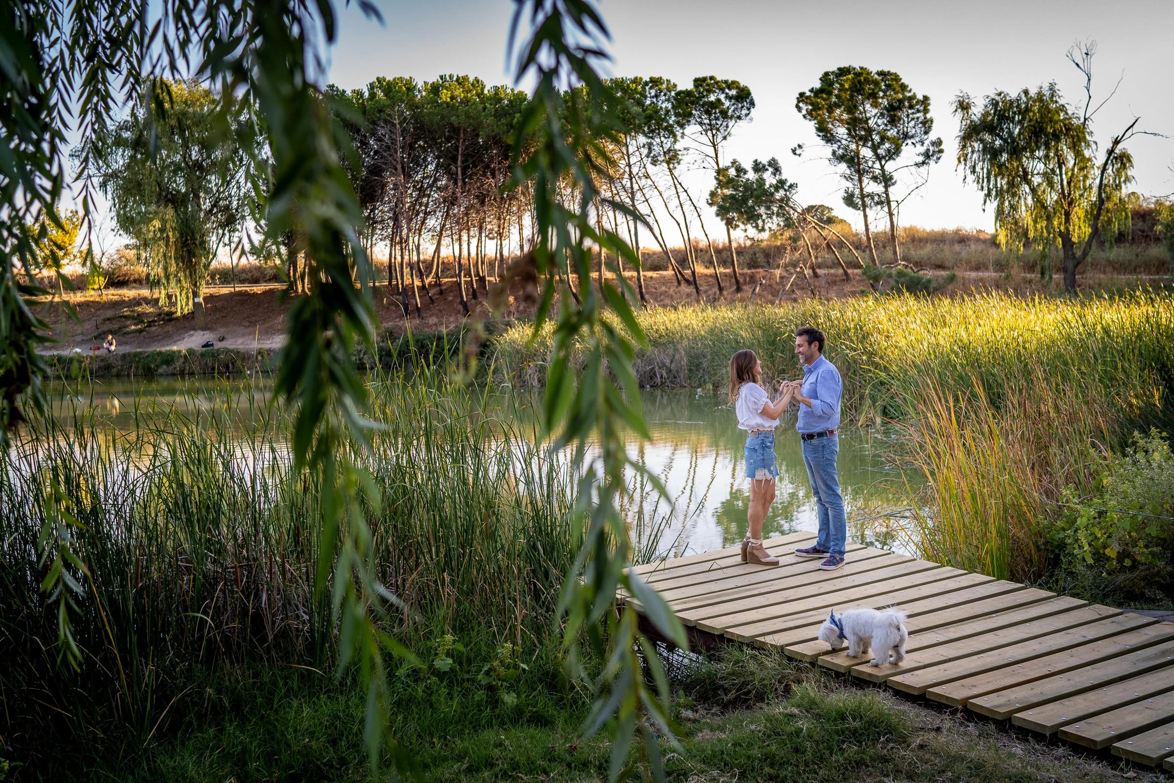 Vanesa y Fran pasean por una pasarela de madera rodeada de vegetación durante su preboda en Madrid.