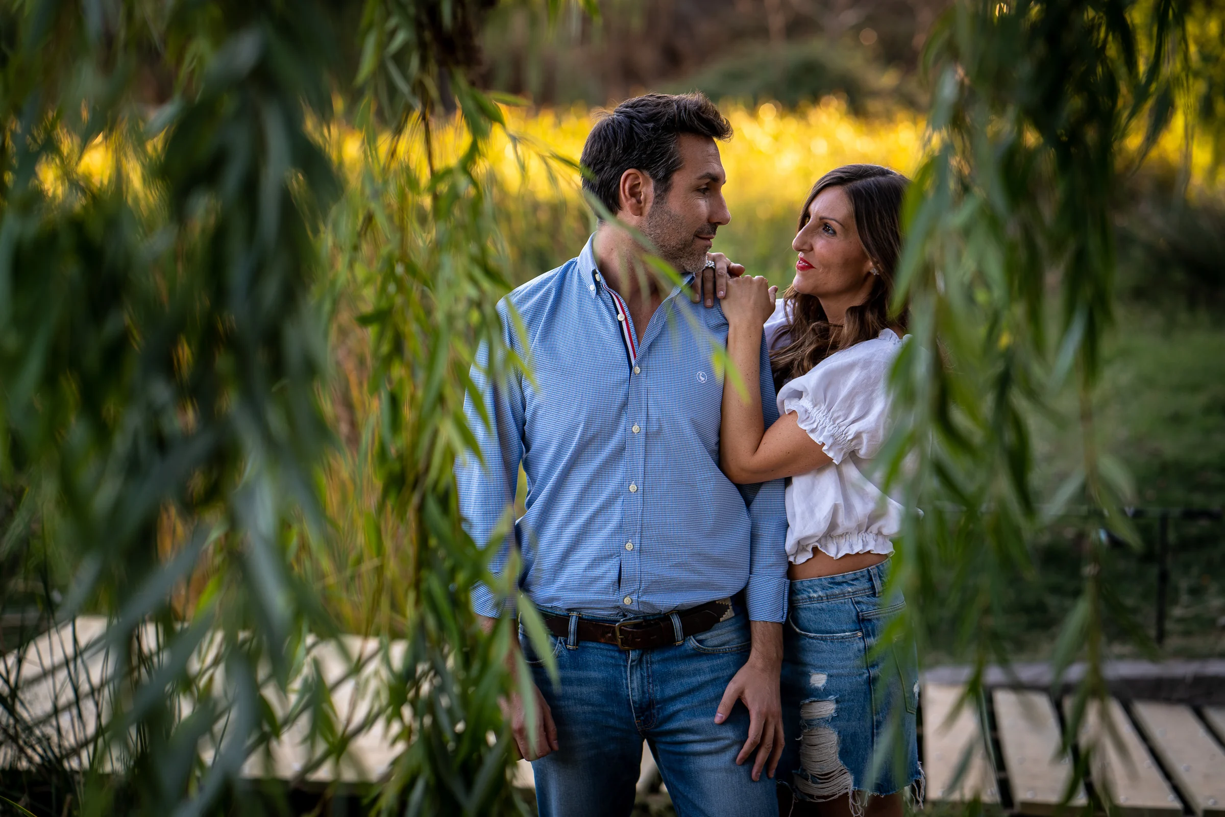 Vanesa y Fran se detienen bajo unos sauces durante su preboda en un parque de Madrid.