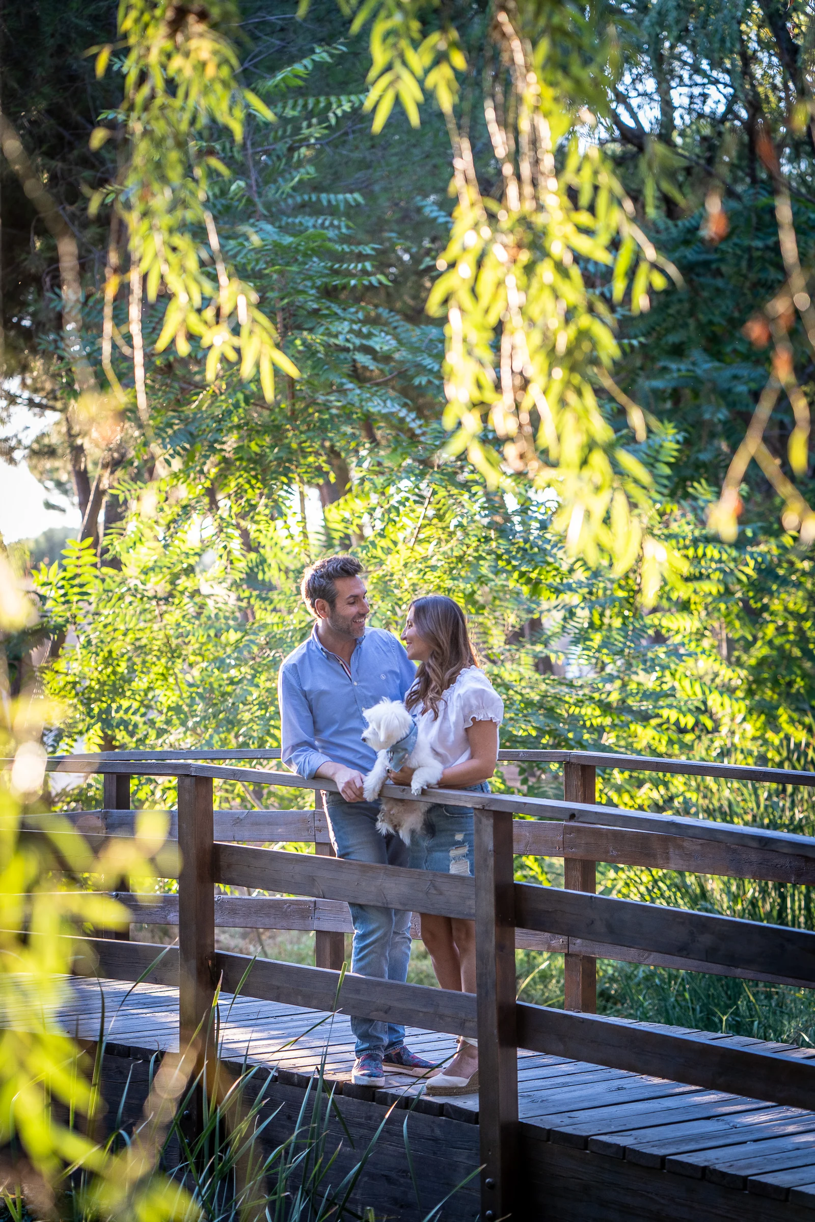 Vanesa y Fran se sientan juntos sobre un puente de madera en su preboda en Madrid.