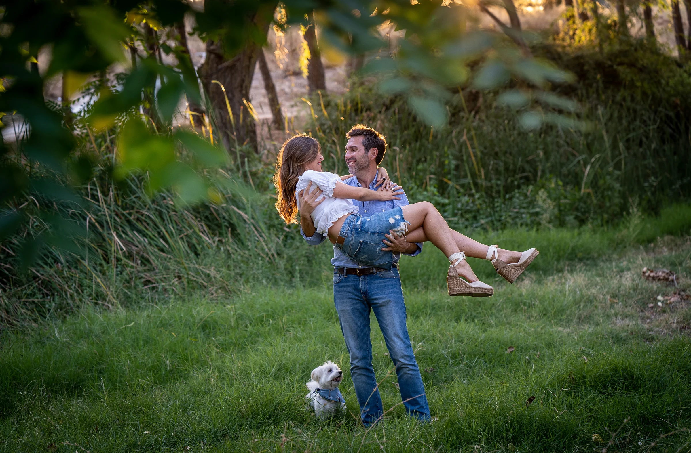 Fran lleva a Vanesa en brazos en un claro del parque durante su preboda en Madrid.