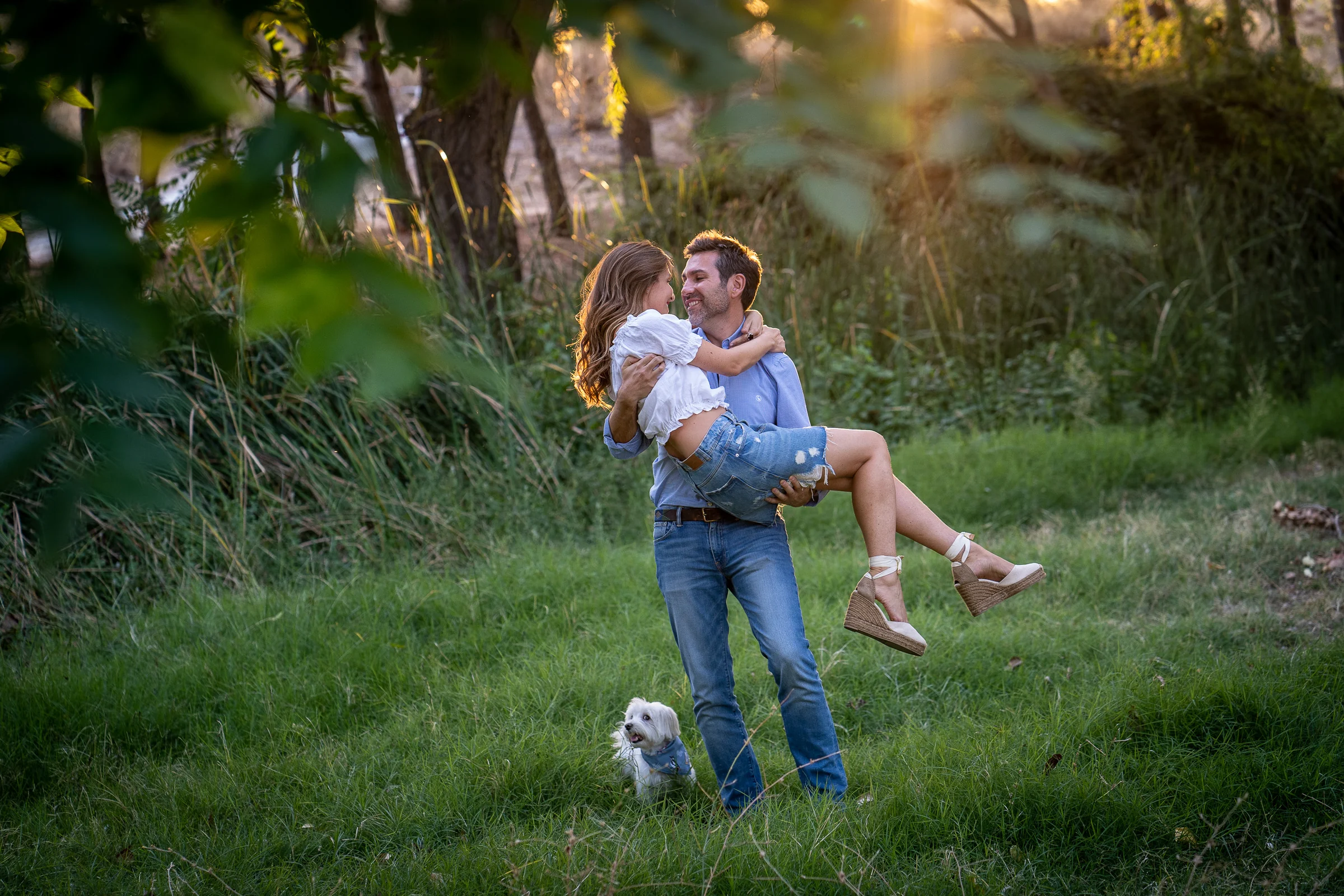 Vanesa y Fran comparten un momento divertido mientras él la sostiene en brazos durante su preboda en Madrid.