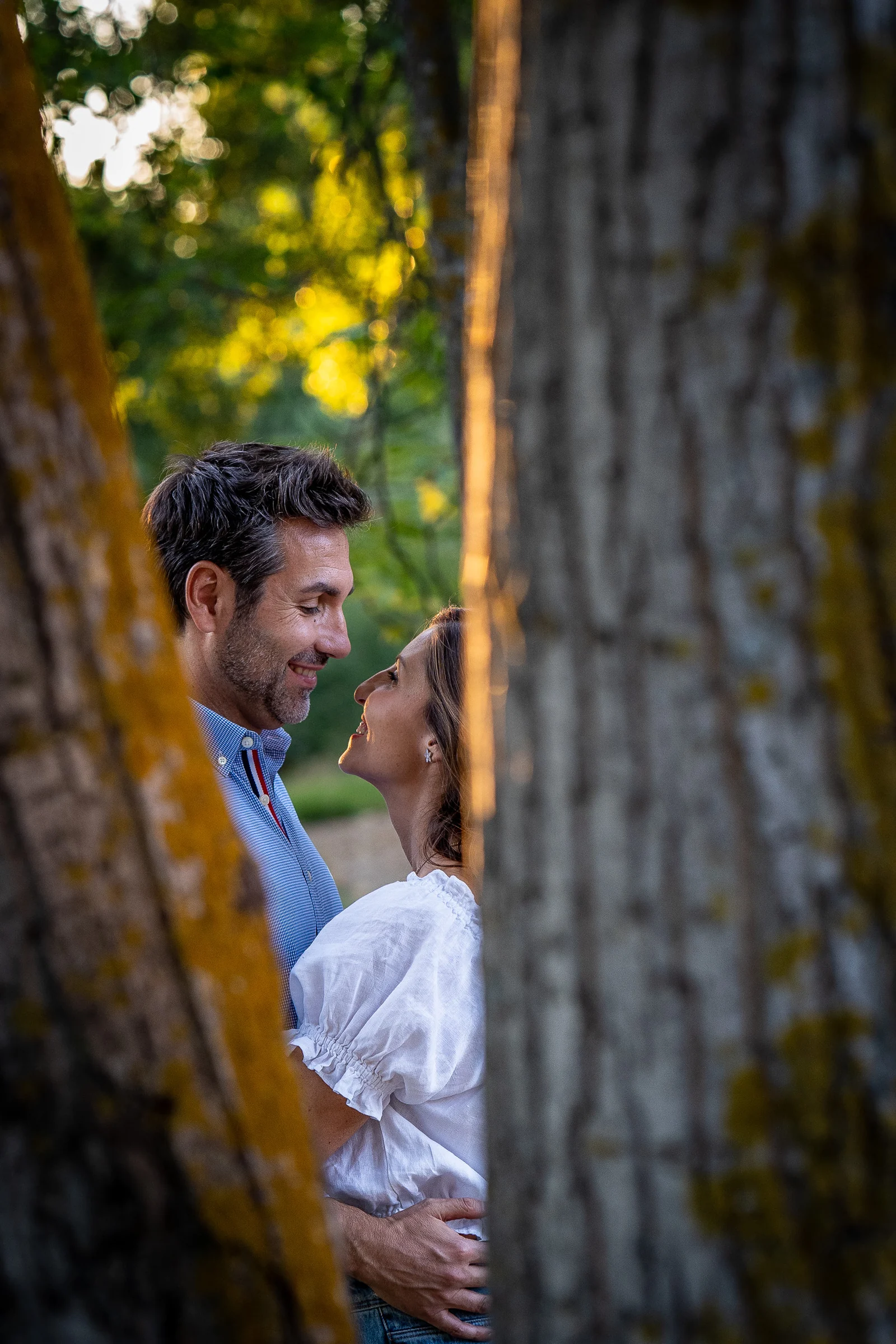 Retrato final de Vanesa y Fran entre los árboles durante su preboda al atardecer en Madrid.